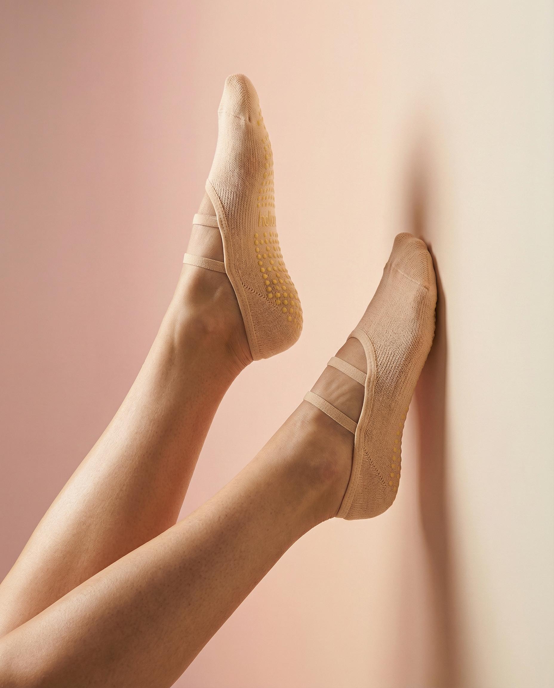 peach ballet grip socks against coloured wall