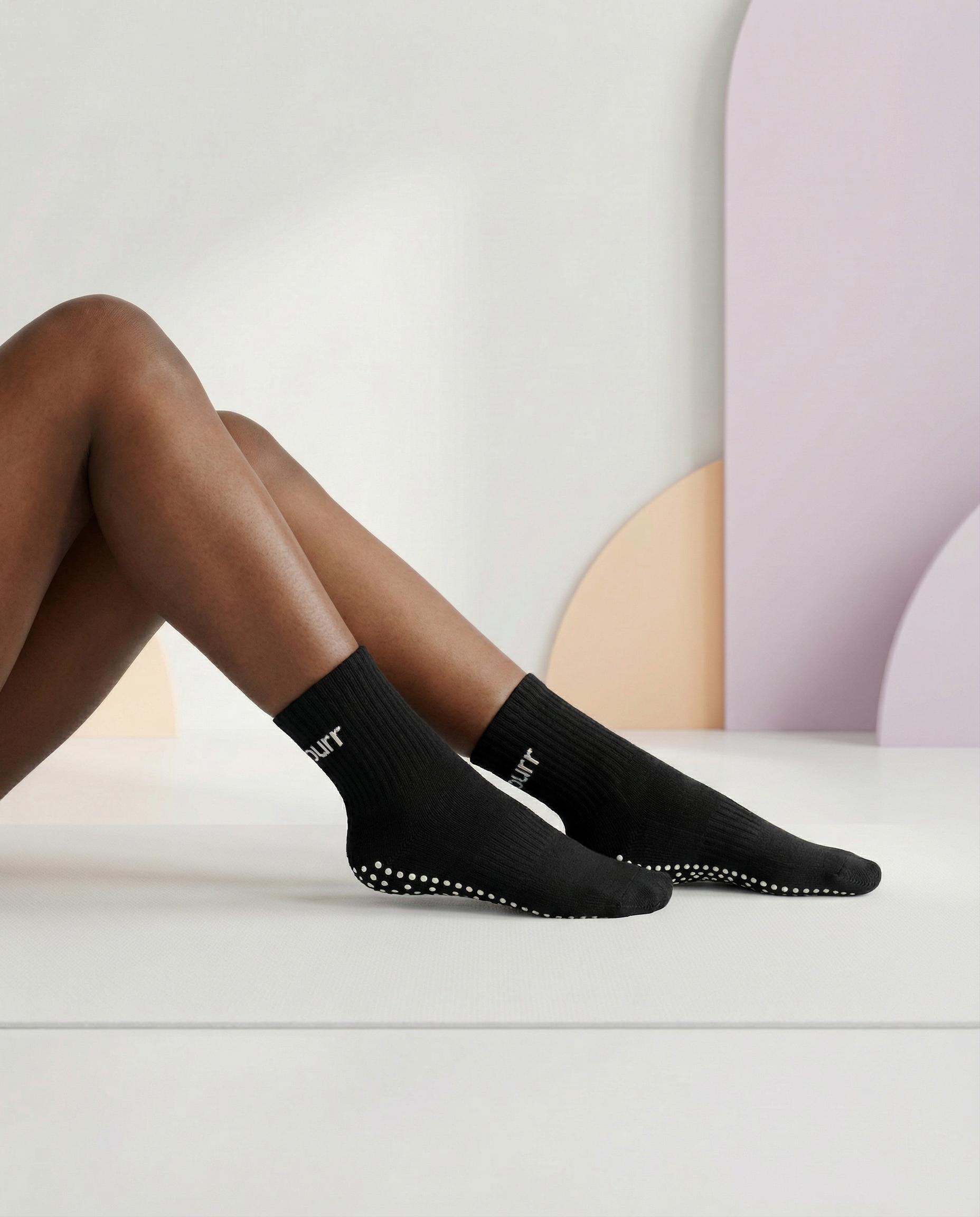 model sitting with black hellour midcrew grip socks